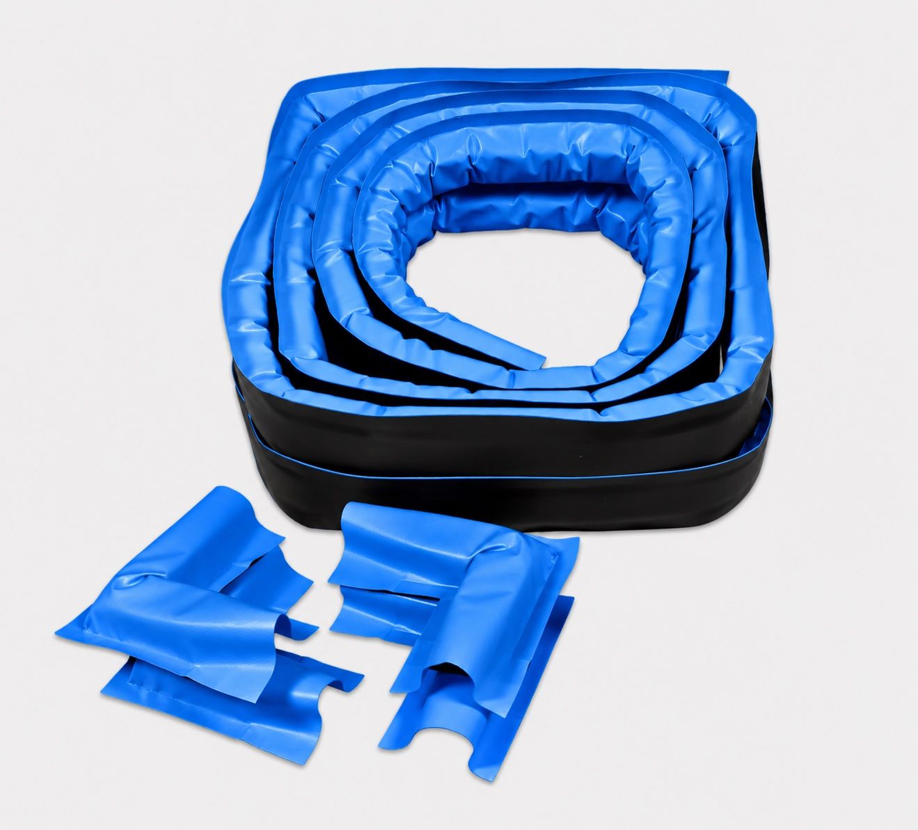 Coiled PVC-covered foam curb wall sections with preformed corner and end pieces laid out in front of them
